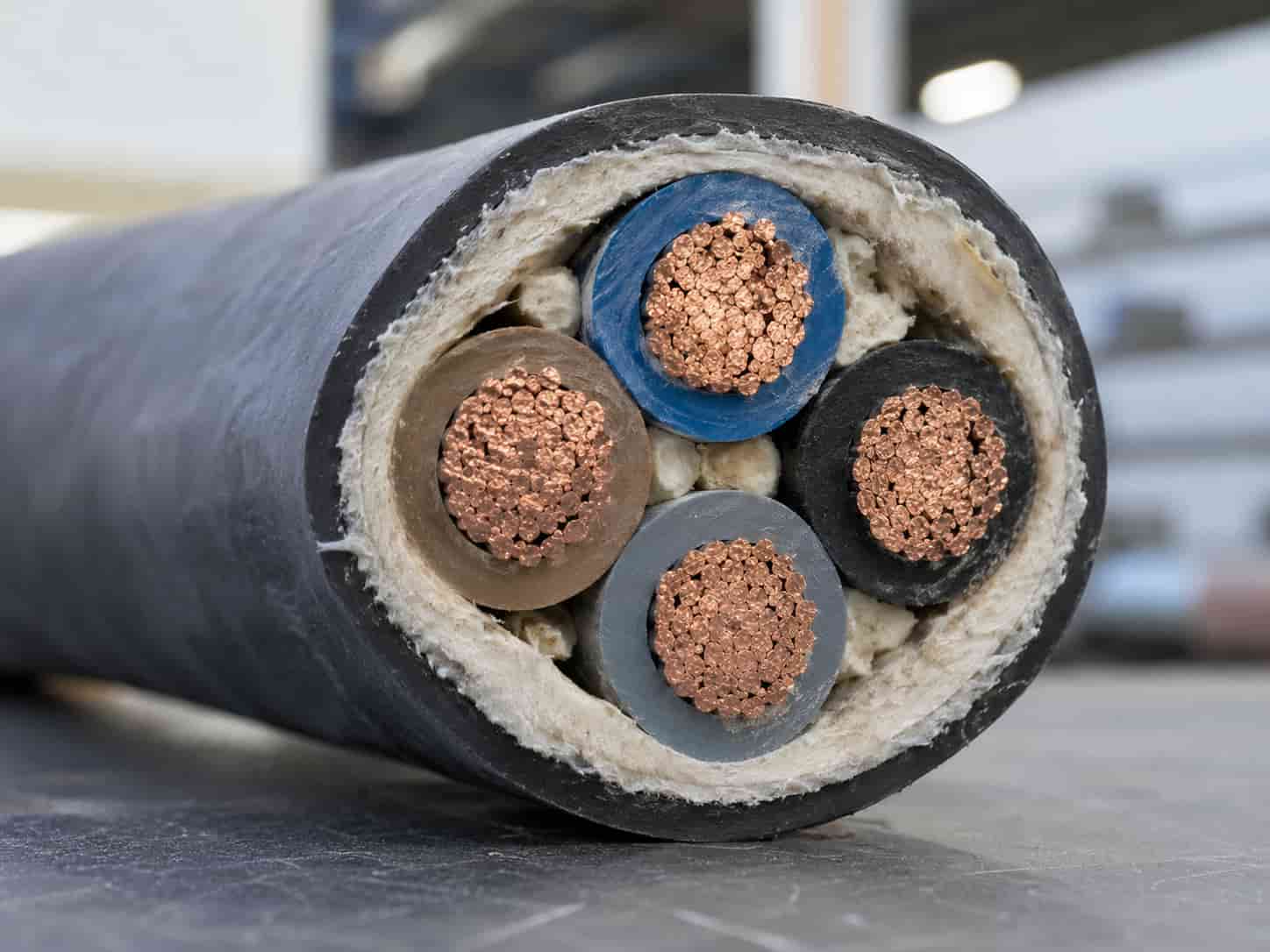 Close-up cross-section of a multi-core low voltage power cable showing copper conductors, colored PVC or XLPE insulation layers, filler material, and outer protective sheath.