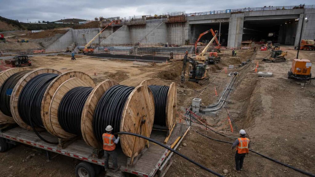 Large construction site with cable drum deliveries, cable laying equipment and infrastructure project electrical installation in progress